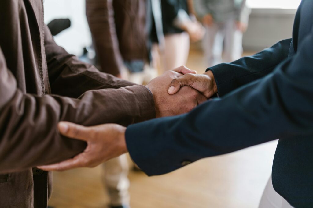 pexels-photo-7414284-7414284 Close-up of two businesspeople shaking hands, symbolizing agreement and partnership.